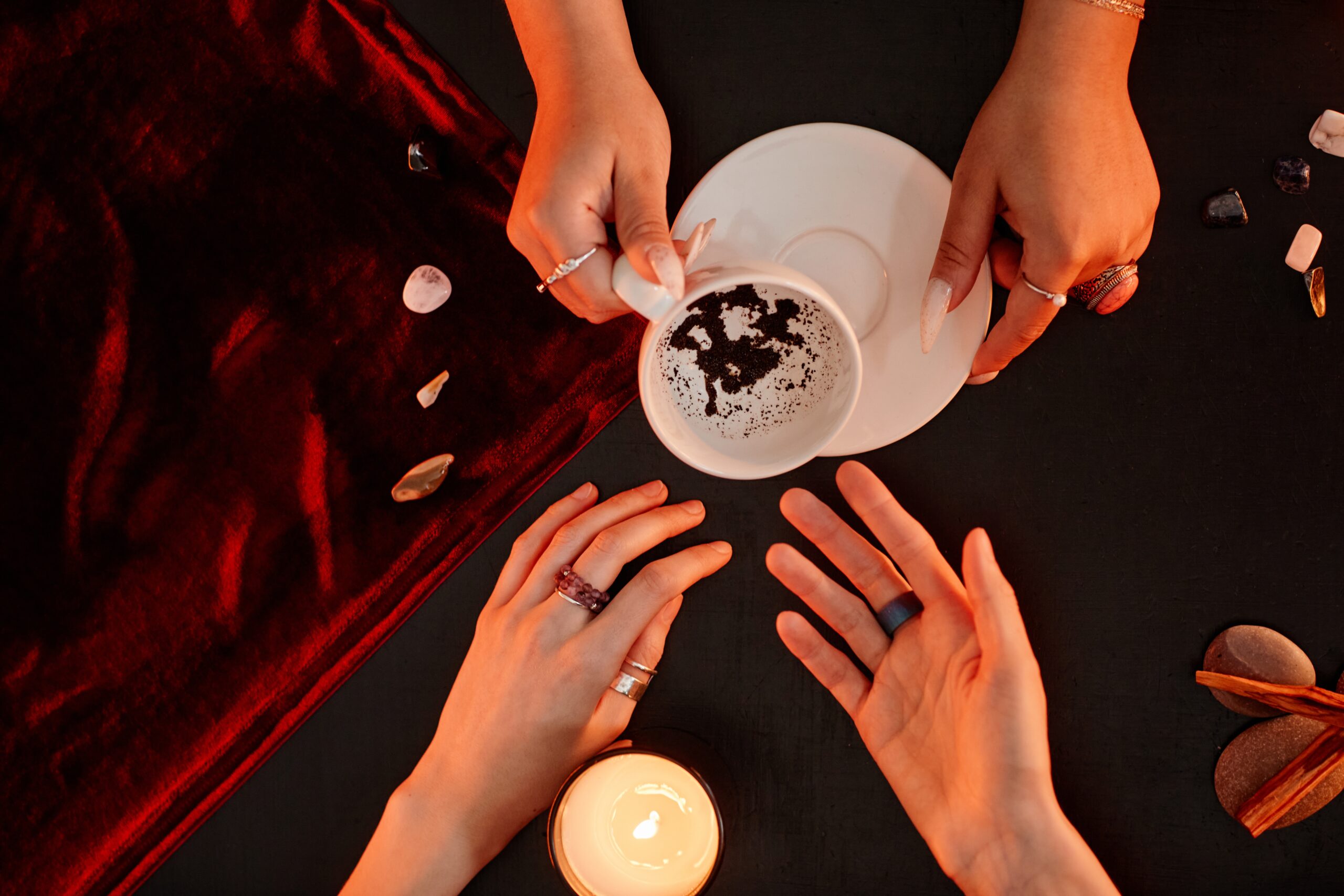 Top down view at female fortune teller reading coffee telling destiny in seance with young woman